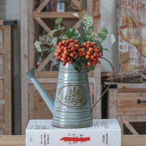 Vintage light blue iron flower pot vase with red berries on rustic wooden books