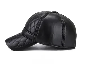 Détail d'une casquette en cuir noir avec surpiqûres en losanges sur la couronne et la visière