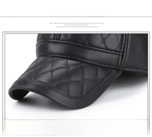 Gros plan de la visière de casquette en cuir noir avec surpiqûres losanges