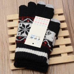 Detail view of winter knit gloves showing touch screen fingertips and snowflake jacquard pattern