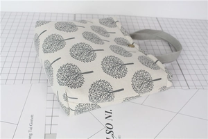 Close-up of cotton linen lunch bag with grey tree pattern and secure button closure