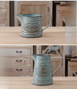 Close-up of vintage rustic metal planters with embossed botanical patterns and aged finish