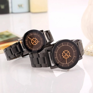 Detail view of black and gold quartz watches for couples with decorative gear patterns