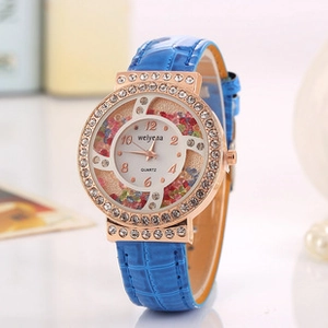 Detail of rose gold watch bezel with rhinestones and colorful crystals inside the dial