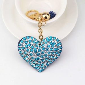 Detail of blue rhinestone heart keychain with gold accents and stylish blue fringe tassel