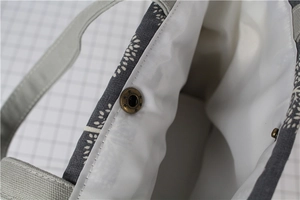 Close-up of canvas lunch bag featuring vintage bronze magnetic buckle and interior lining