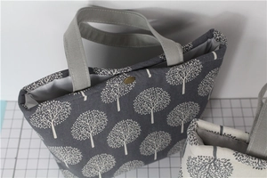 Detail of canvas lunch bag with tree print and bronze metal snap button closure