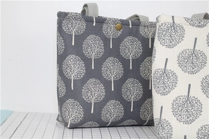 Detail view of cotton linen lunch bag with metal snap button and forest tree pattern