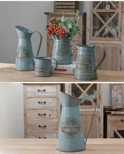 Close-up of vintage French style blue metal pitcher with rustic iron-rust finish and embossed text