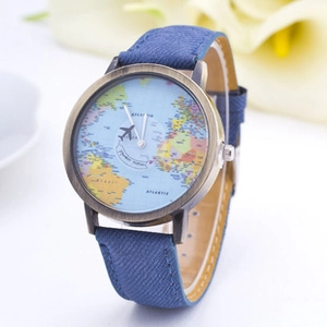 Detail of world map watch face with airplane second hand and blue fiber strap