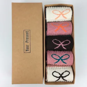 Five pairs of wool Christmas socks with bow patterns in a kraft gift box packaging