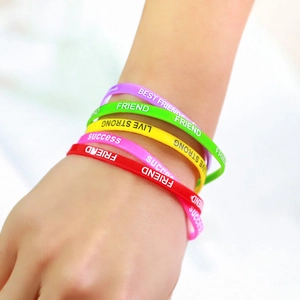 Close-up of colorful silicone wristbands featuring white motivational printed text