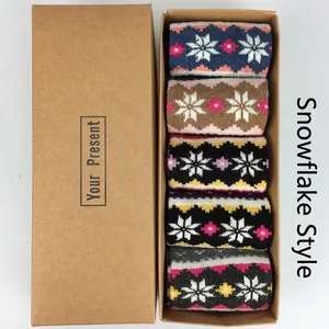 Five pairs of winter wool socks with snowflake patterns in a brown gift box