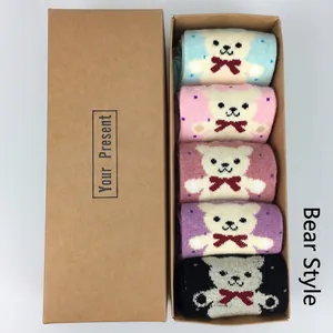 Close-up of five pairs of wool socks with bear pattern in a kraft gift box