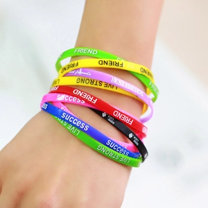 Close-up of stacked colorful silicone wristbands with inspirational printed text