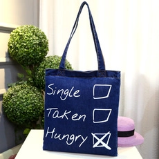 Close-up of blue denim tote bag with funny Single Taken Hungry checkbox print design
