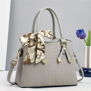 Détail du sac à main gris motif pierre avec boucle cœur et foulard en soie au manche