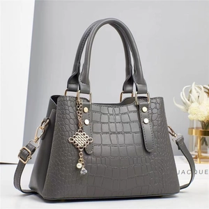 Sac à main gris gaufré crocodile avec détails dorés et pendentifs décoratifs