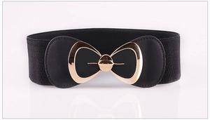 Detail of black elastic waist belt featuring a decorative gold-trimmed bow buckle