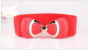 Detail of red elastic waist belt featuring a gold bow buckle and elegant floral decor