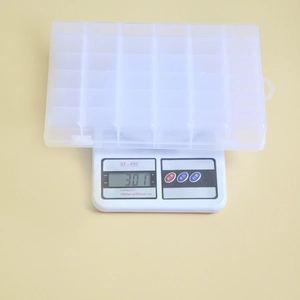 Detailed top view of 28-compartment clear plastic storage box on a scale weighing 301g