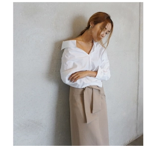 Chic model style showing minimalist silver geometric hoop earrings with a white blouse