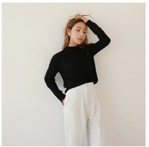 Minimalist black long sleeve knit top paired with white high waist wide leg trousers