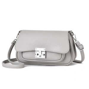 Detail of grey pebble grain leather crossbody bag featuring a silver square metal clasp
