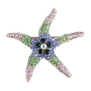 Fashionable starfish brooch with colorful rhinestones and gold base on a white background