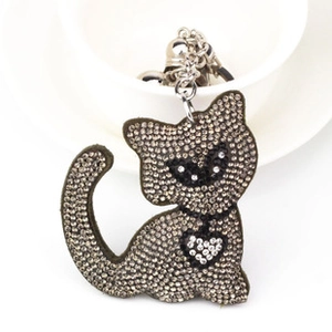 Detailed close-up of a sparkling grey rhinestone cat bag charm with white heart stone