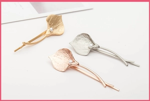 Detail of calla lily hair clips with textured metal petals and elegant pearls
