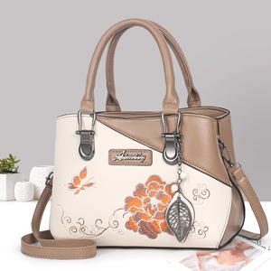 Sac à main élégant beige et marron avec broderie florale et breloque en feuille