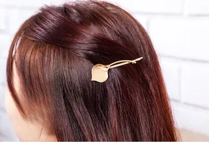 Detailed view of matte gold calla lily hair clip with pearl accent on hair