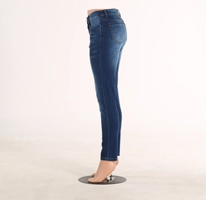 Detailed side view of slim fit dark blue denim jeans with whiskers on a leg mannequin