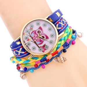 Close-up of bohemian multi-layer wrap watch with owl dial and sea shell charms