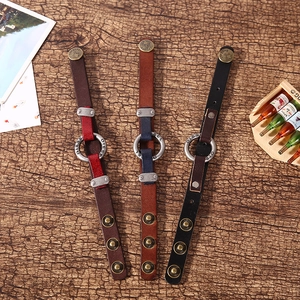 Close-up of vintage leather punk bracelets with metallic studs on dark wood background