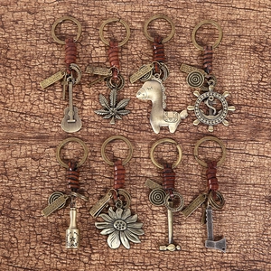 Detailed close-up of vintage leather keychains with bronze pendants on wood