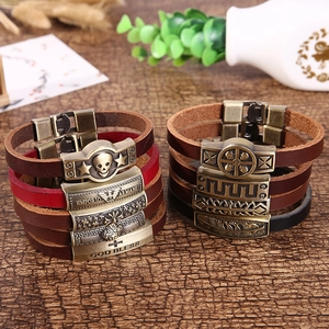 Macro shot of vintage multilayer genuine leather bracelets with bronze metal charms
