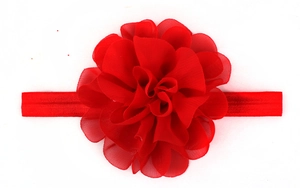 Detail of red chiffon flower baby headband with matching elastic band on white background