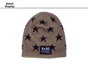 Detail view of coffee brown knit beanie featuring black star patterns and woven patch