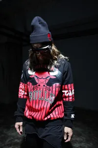 Detailed close-up of a black knit beanie featuring a red skull embroidery and sporty design
