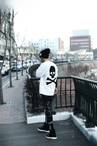 Detail of knit beanie with skull pattern and punk streetwear graphic on white t-shirt