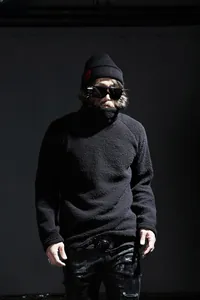 Detail of black knit beanie with red skull embroidery and fuzzy texture high collar sweater