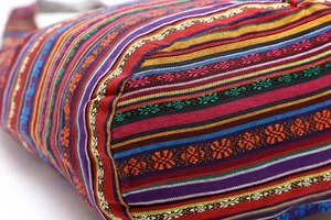 Close-up of colorful ethnic woven fabric with geometric patterns on bucket bag