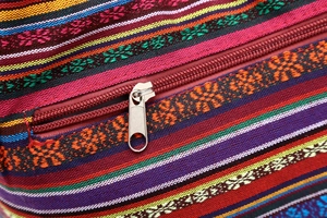Detail shot of colorful ethnic woven fabric texture and premium silver metal zipper