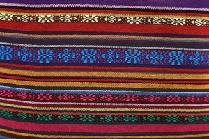 Close-up of vibrant ethnic woven fabric with colorful geometric patterns and texture