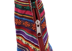 Detailed macro view of ethnic style woven canvas bag with vibrant colorful stripes and zipper