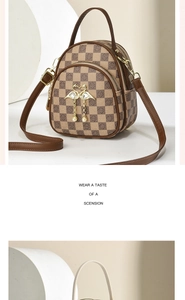 Detail of checkered mini backpack with golden swan buckle and pearl tassel accessory