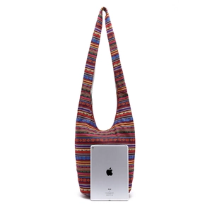 Ethnic bohemian canvas hobo bag with colorful stripes shown next to an iPad for size