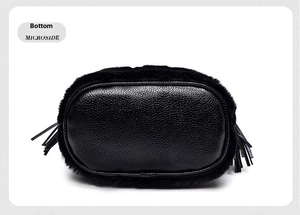 Detail view of the black faux fur bucket bag featuring a textured pebbled leather base